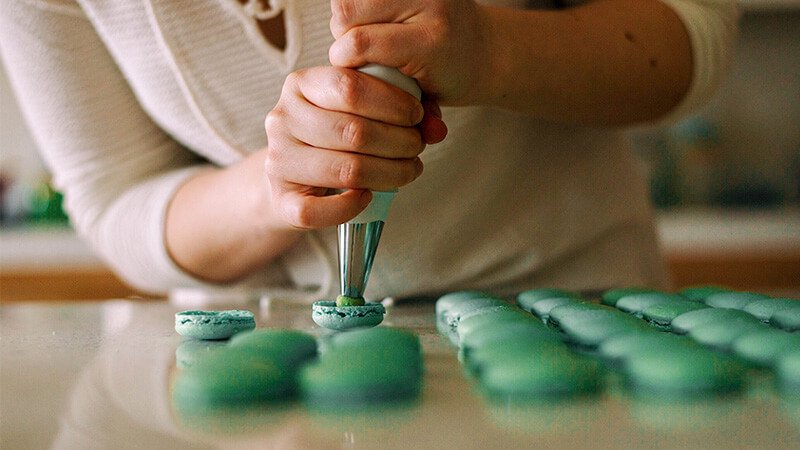 a chef making green macaroons