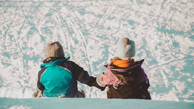 ski season jobs, two children sat in the snow