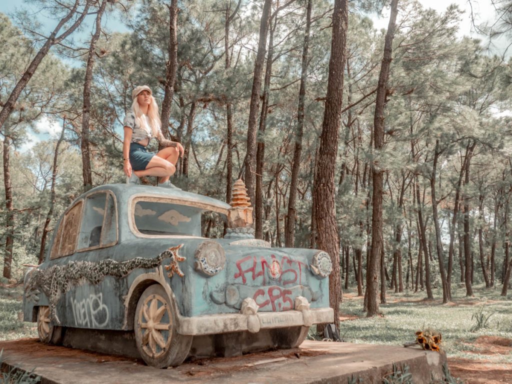 is Ho Thuy Tien worth visiting? I certainly think so, woman on top of graffiti covered concrete car structure.