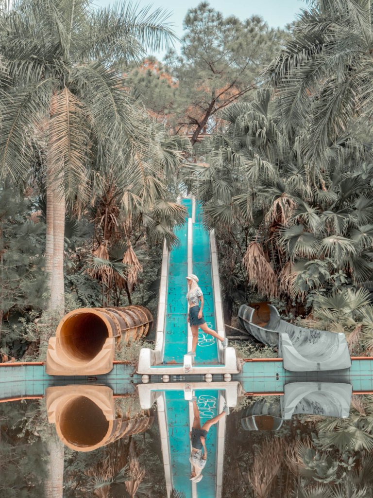 woman walking across the bottom of the slide in Ho Thuy Tien, reflected in the water.