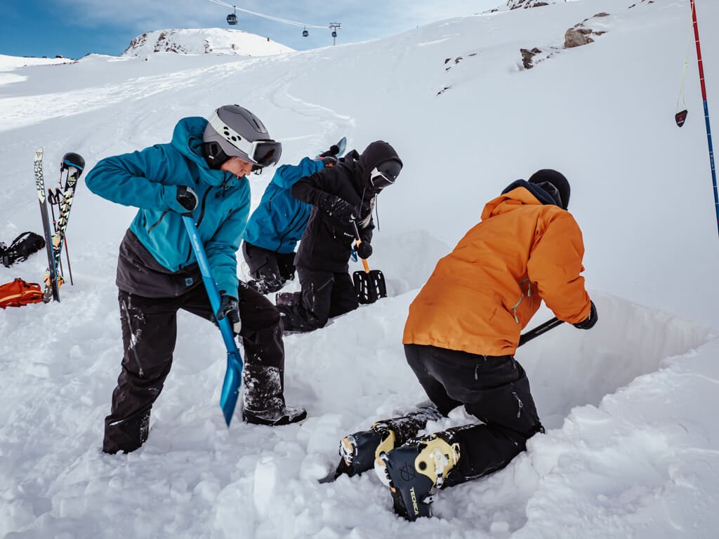 Skiers and Snowboarders learning to dig a snowpit  whilst off-piste skiing in Zermatt.