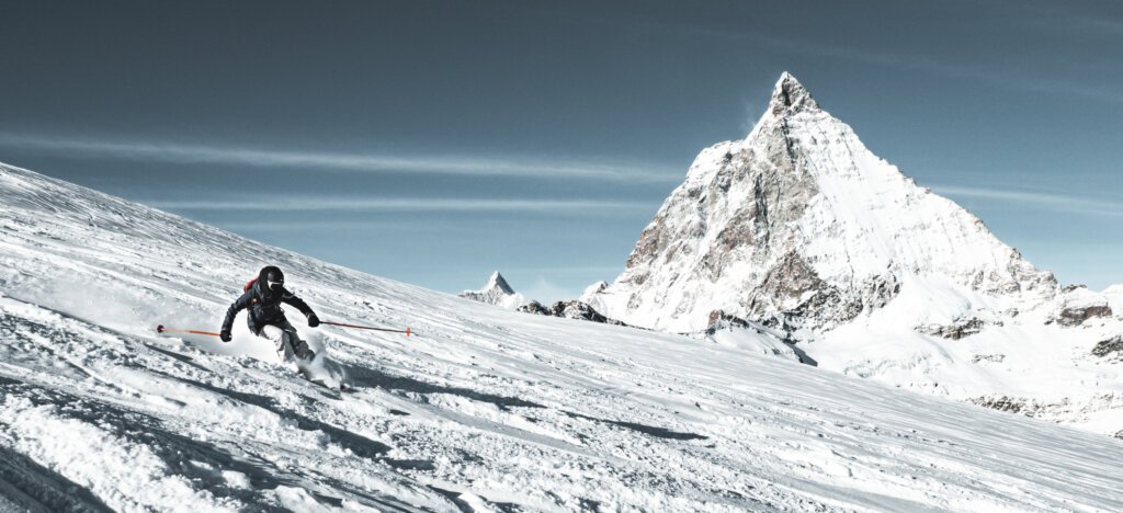 Woman off-piste skiing in front of the Matterhorn