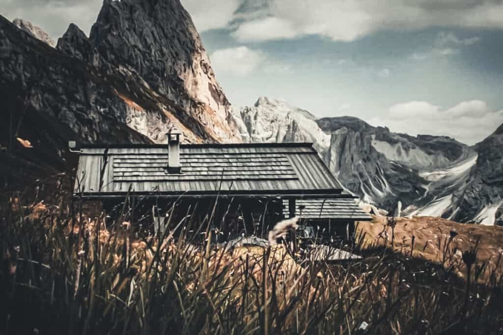 mountain hut with dramatic mountain backdrop