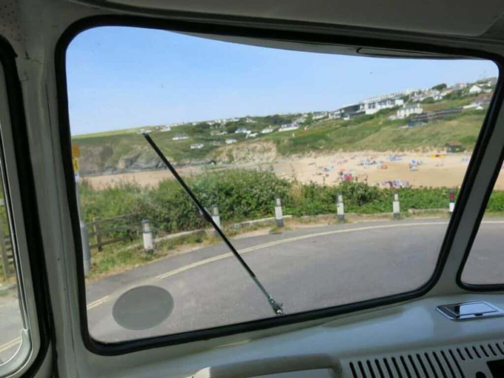 The view from the dashboard of a classic vw campervan of a Cornish beach.