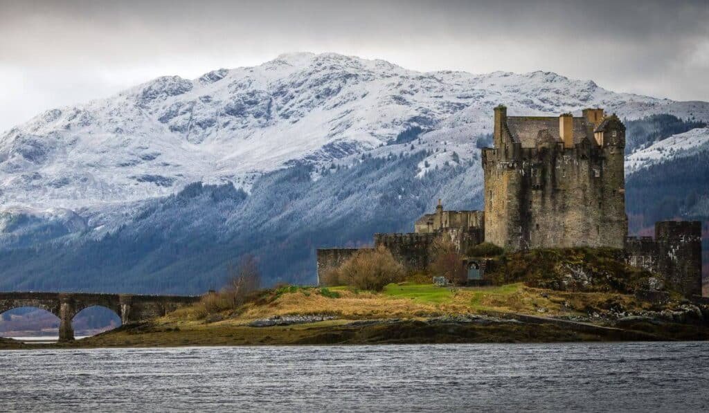 Eilean Donan Castle Scotland, with a snow caped mountainous backdrop.