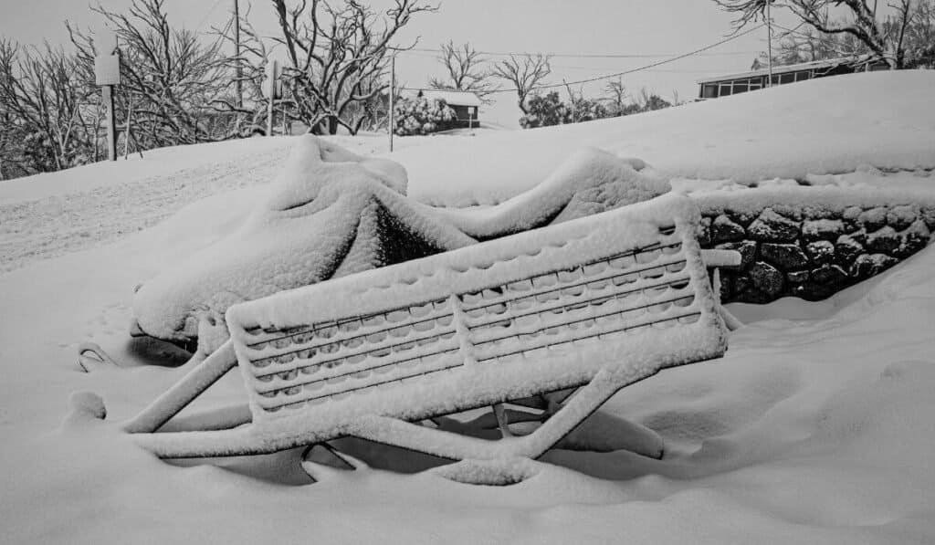 Snow covered bench during winter in the Australian Alps, this should answer the question of does it snow in Australia.