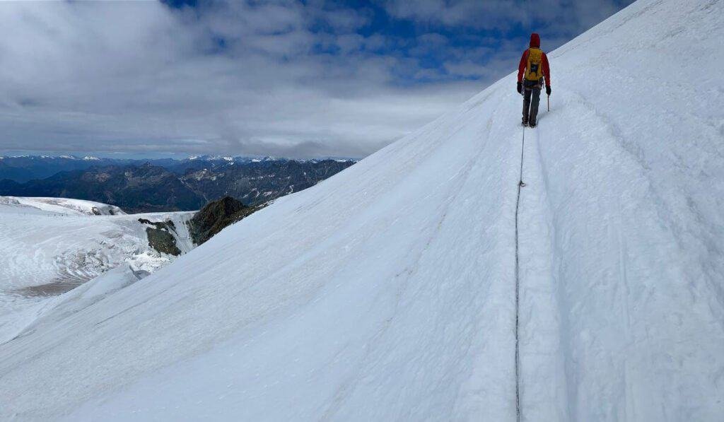 Man walking up the snow covered peak of Breithorn, Switzerland