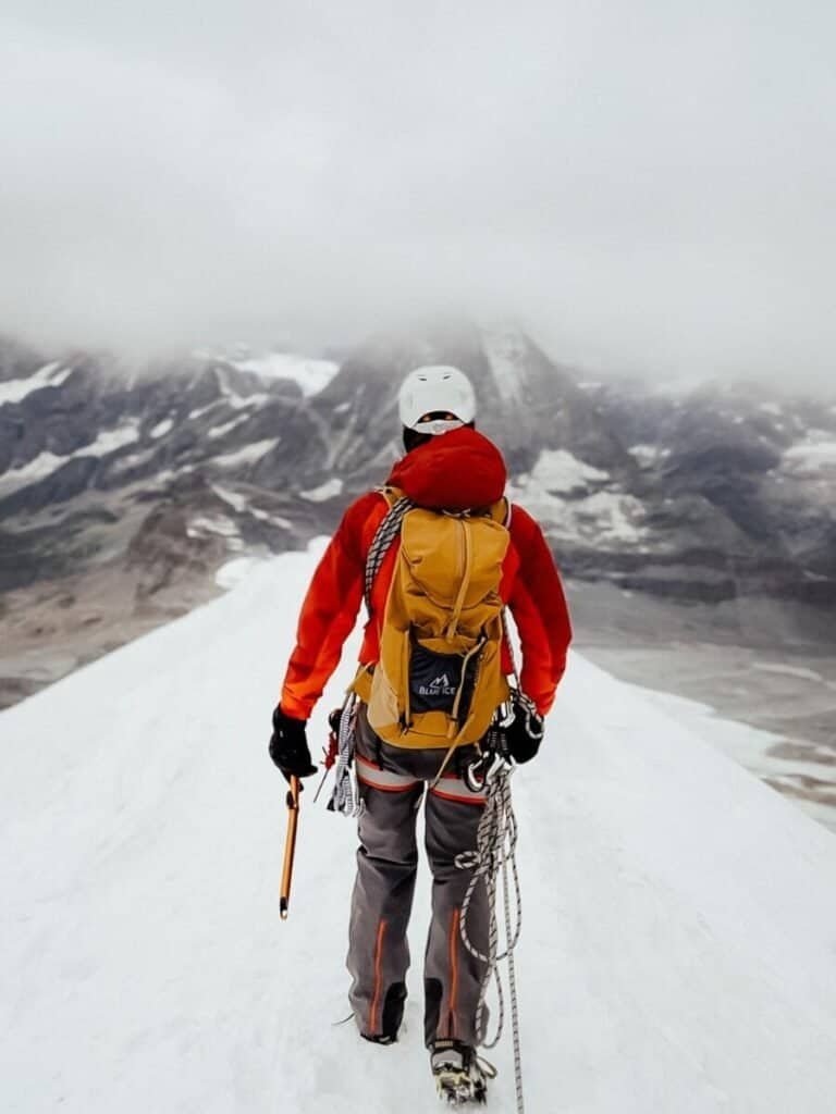 Mountaineer walking along the summit of Breithorn in Switzerland.