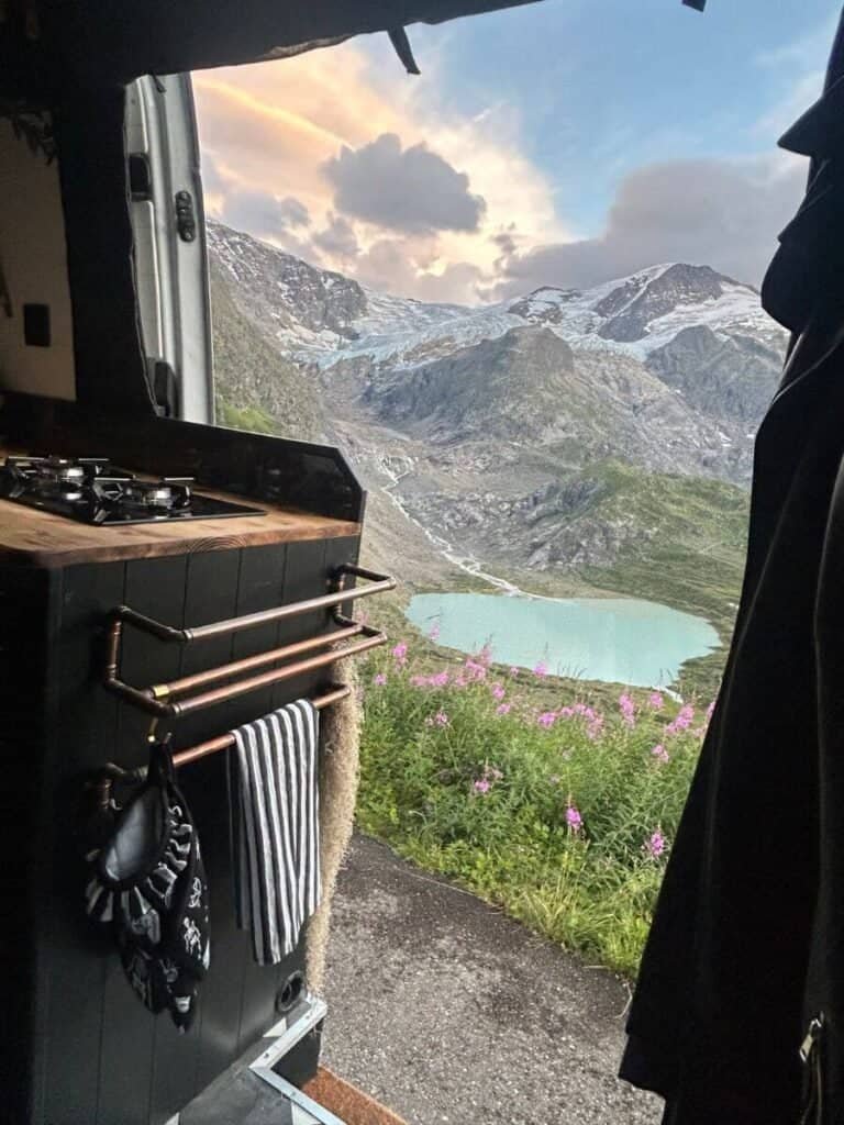 A view from a campervan kitchen, overlooking the lakes and mountains from the Süstenpass, this is vanlife in Switzerland.