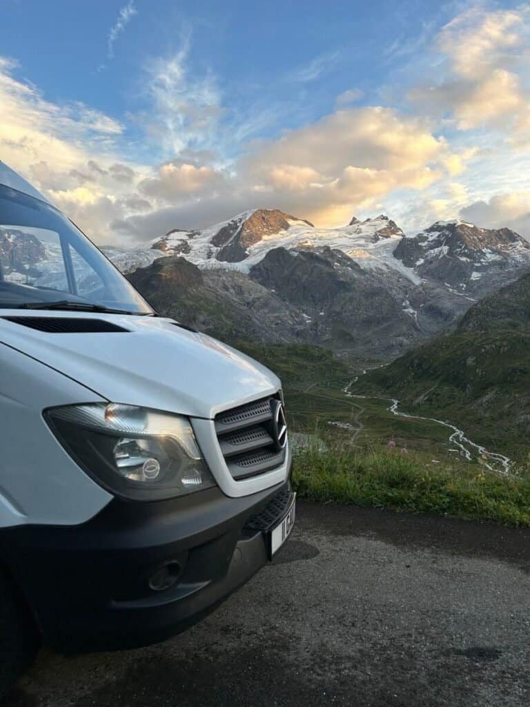 The front of a campervan overlooking the Swiss Alps.